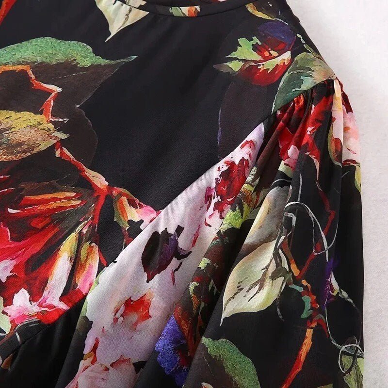Black floral blouse with colorful prints, featuring lightweight fabric and elegant puff sleeves. Perfect for casual outings.