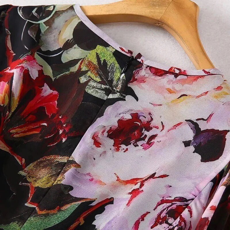 Floral print blouse in vibrant red, purple, and black, featuring a lightweight fabric and elegant round neckline.