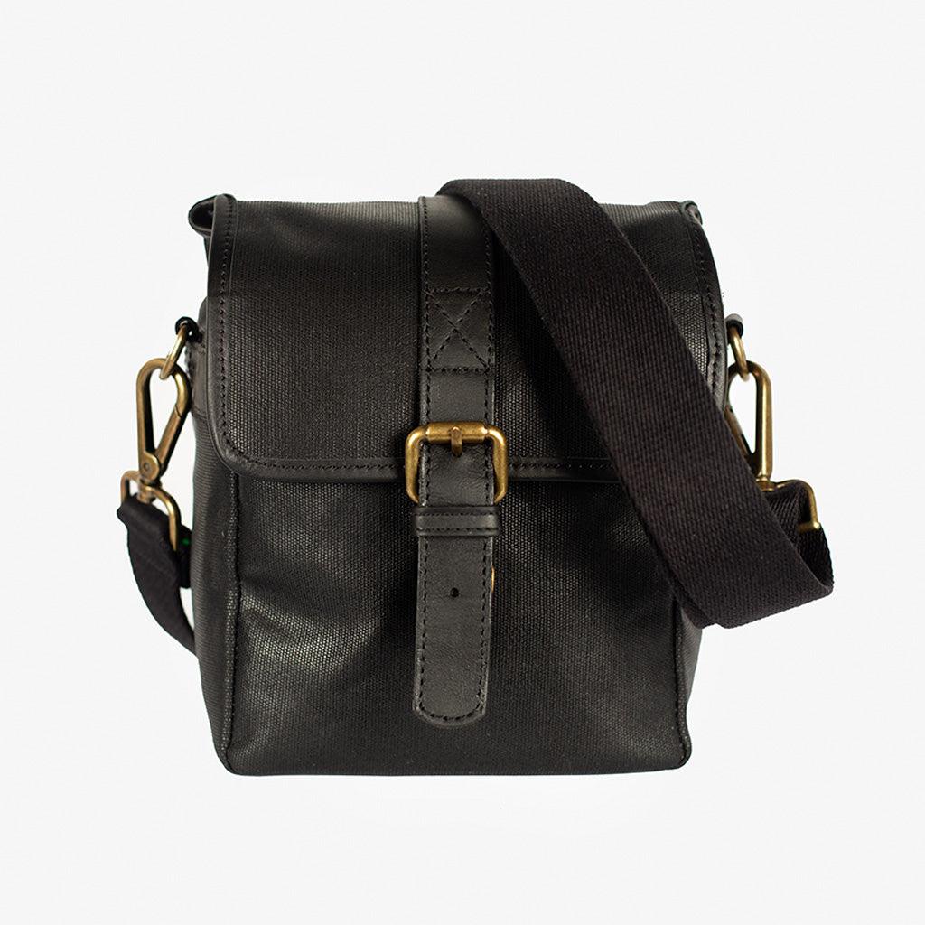 Waxed canvas camera bag Berlin in black, front view with brass closure and side flaps – handcrafted, water-repellent, compact design