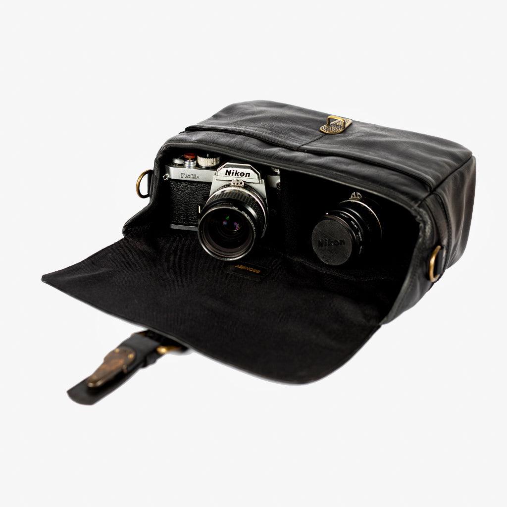 Paris black leather camera bag holding camera and lenses inside