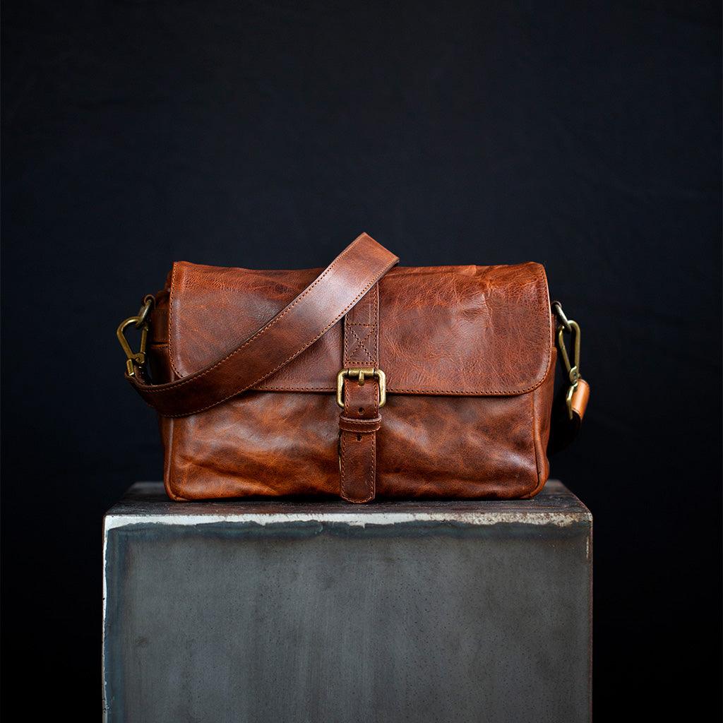 Handmade leather camera bag with brass closure and crossbody strap