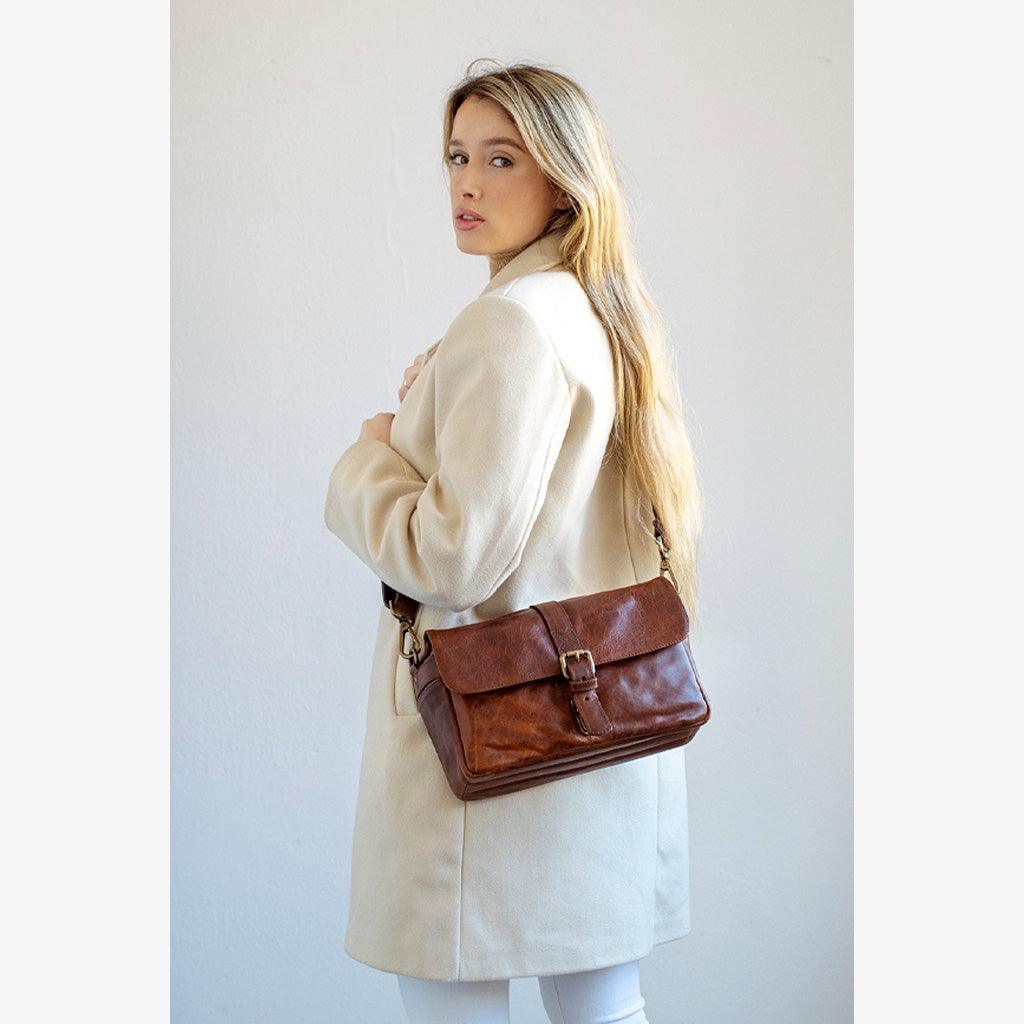 Model showcasing a Handmade leather camera bag during a stylish photoshoot, emphasizing elegance and craftsmanship.