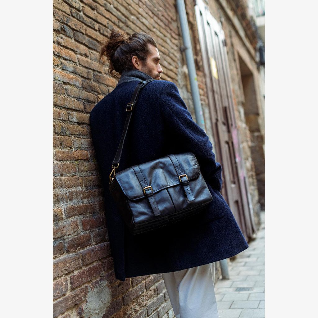 Bolso de Cuero Negro Roma con diseño clásico y elegante, cuero natural resistente, cierres de latón macizo y solapas laterales que protegen tu equipo con estilo