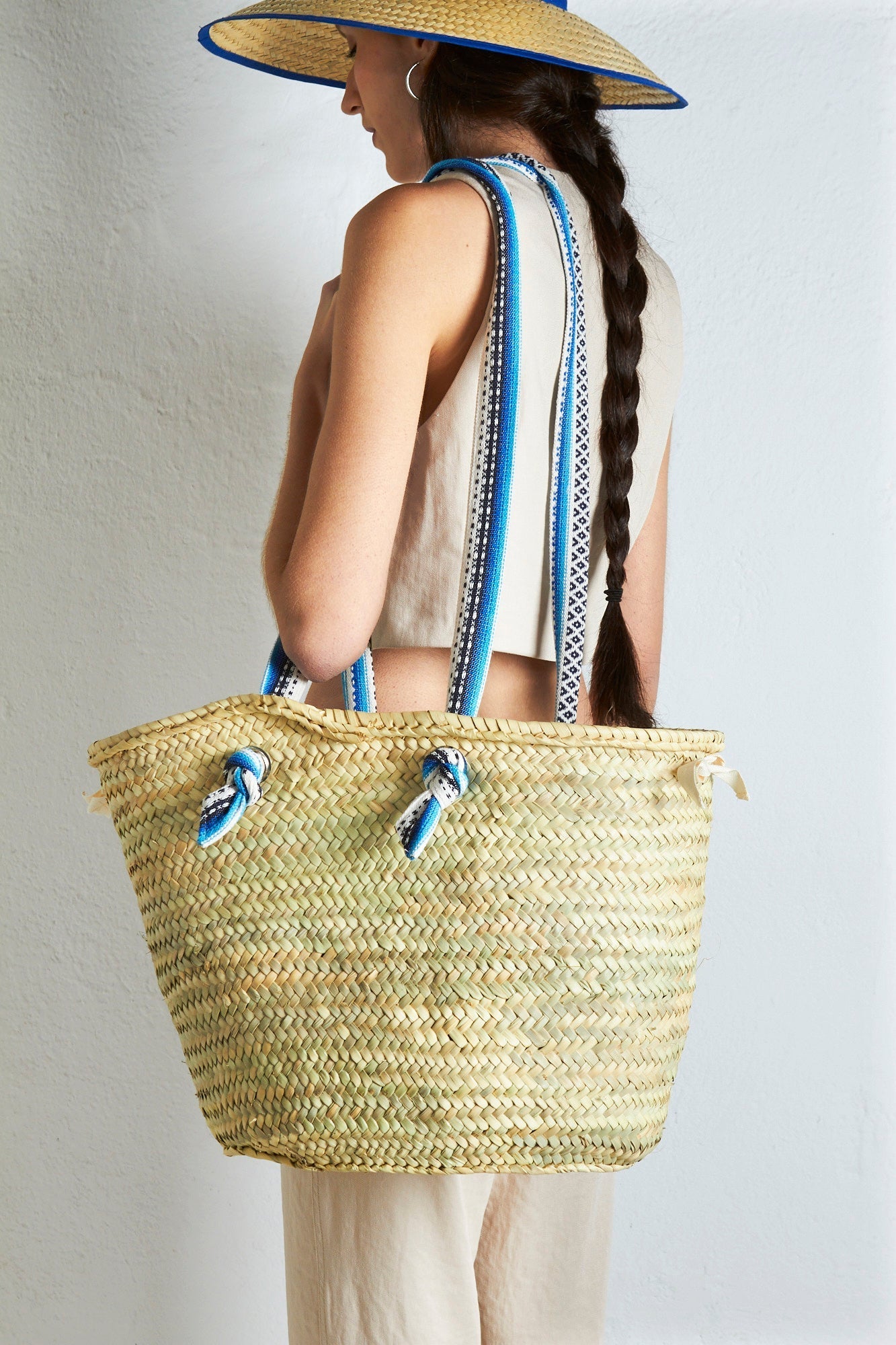 Bolso de playa de paja trenzada, color beige con asas de rayas azules y blancas, estilo bohemio.