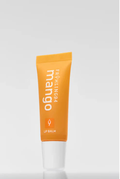 Orange mango-scented lip balm tube labeled "FRÜHLING94" with white text on a soft, light gray background.