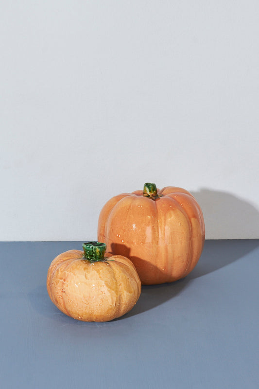 Calabazas decorativas de cerámica en tonos naranjas y verdes, ideales para adornos de otoño.