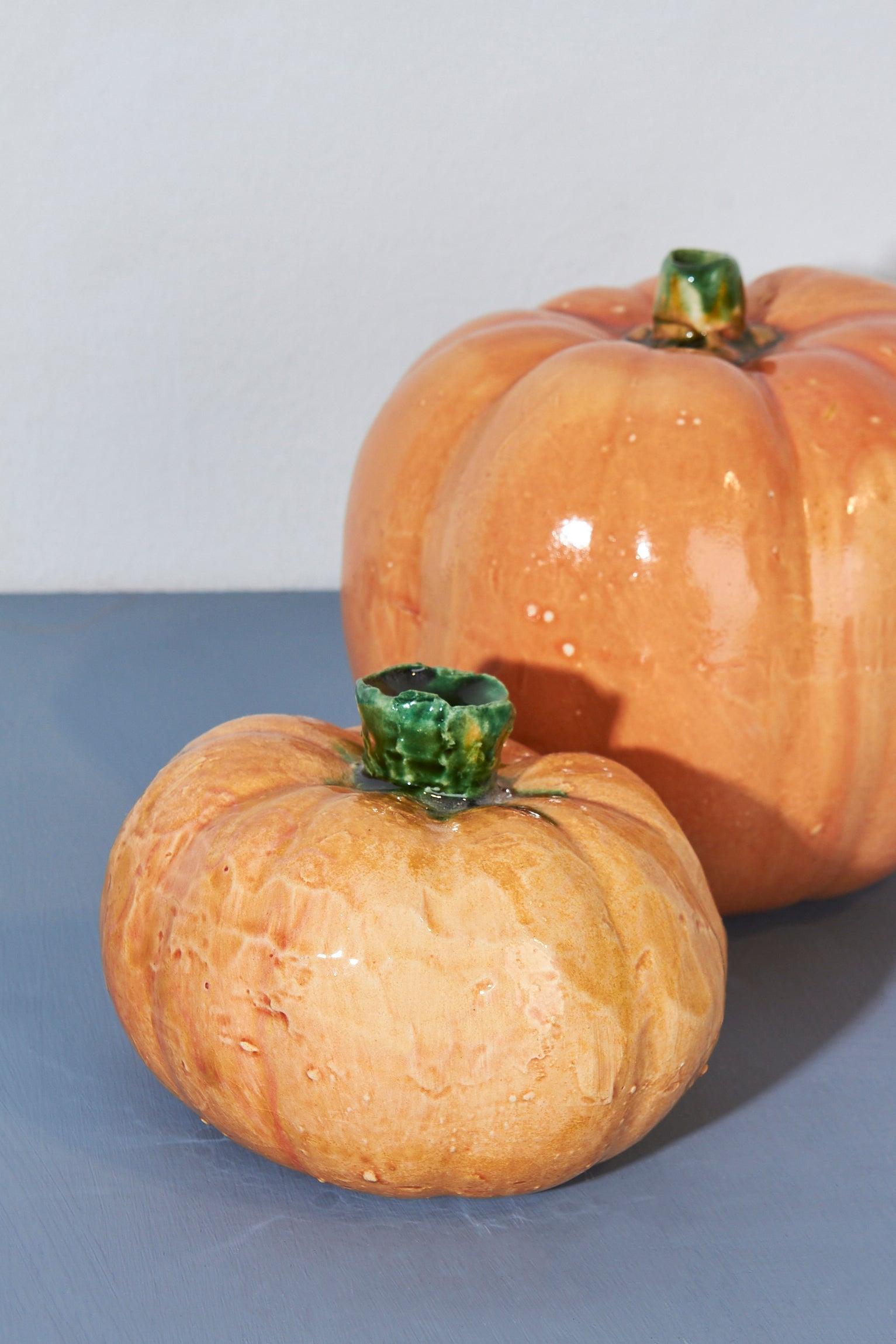 Calabazas de cerámica color naranja con tallos verdes, decorativas para otoño y Halloween.