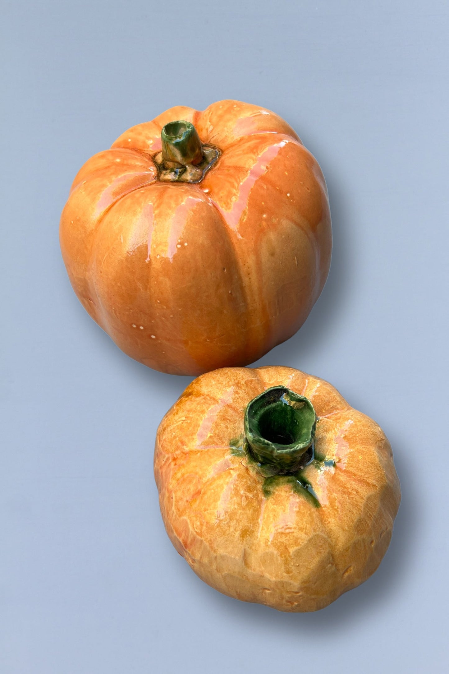 Calabazas de cerámica brillantes en tonos naranjas y verdes, decorativas y artesanales, ideales para otoño.