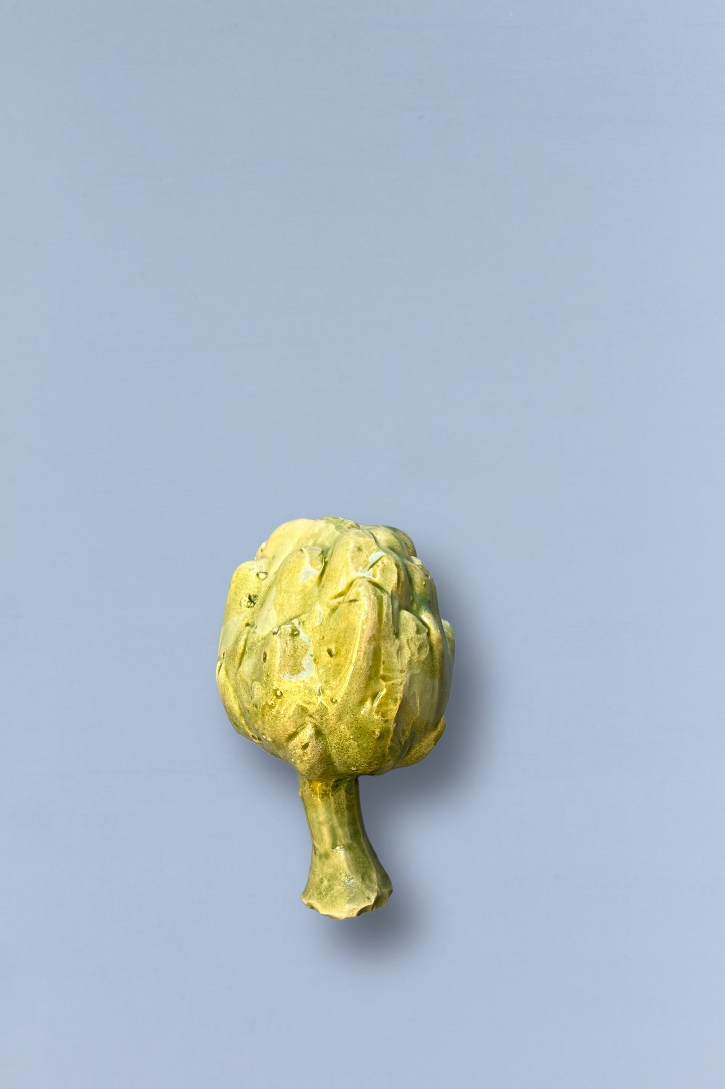Alcachofa fresca verde sobre fondo gris, ideal para ensaladas y platos saludables.