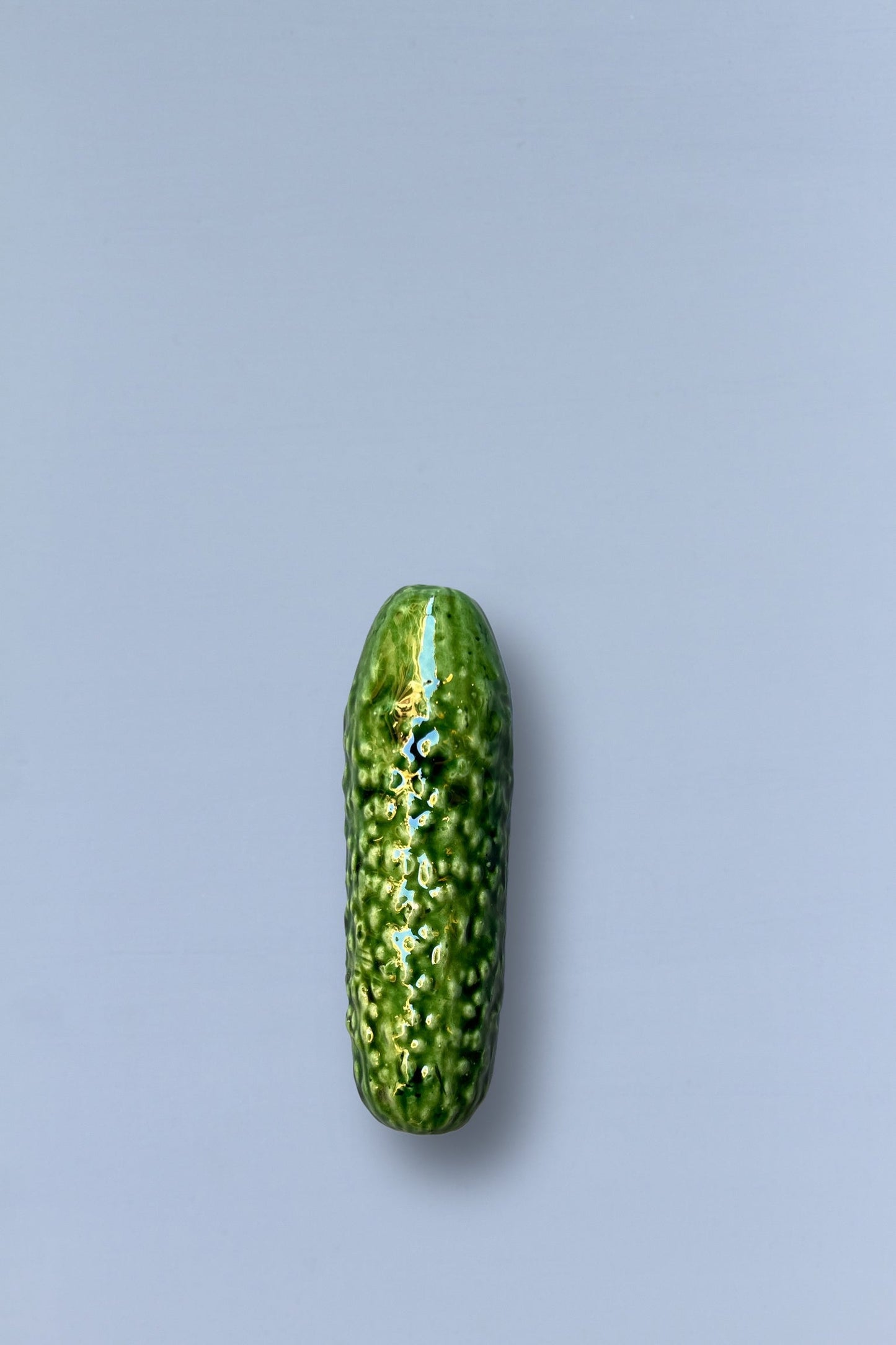 Pepinillo de cerámica verde brillante, estilo moderno y detallado, ideal para decoración o regalo.