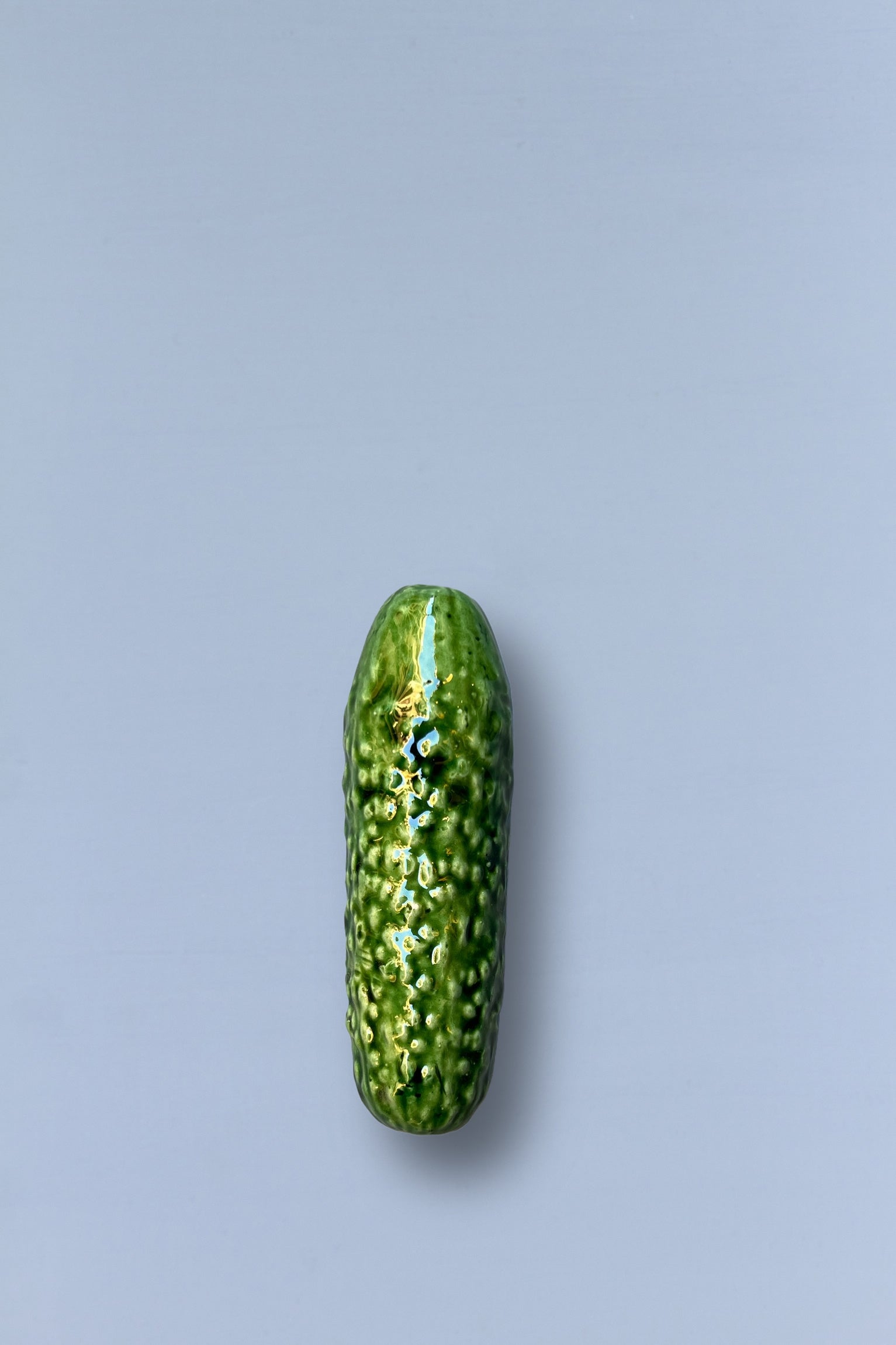 Pepinillo de cerámica verde brillante, estilo moderno y detallado, ideal para decoración o regalo.
