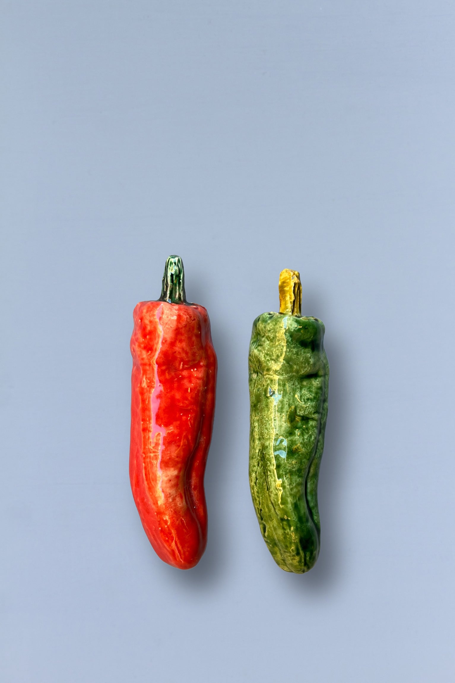 Pimientos de cerámica roja y verde, con detalles en dorado, estilo moderno y decorativo para cocina.