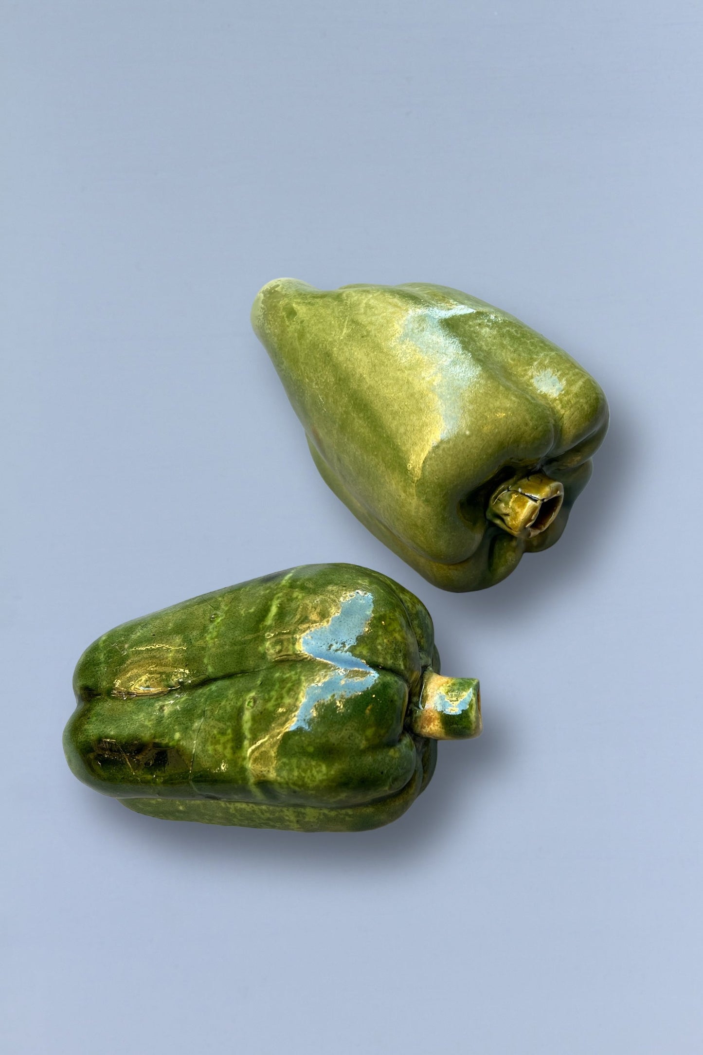 Pimientos de cerámica verde, brillante y artesanal, ideales para decoración de cocina.