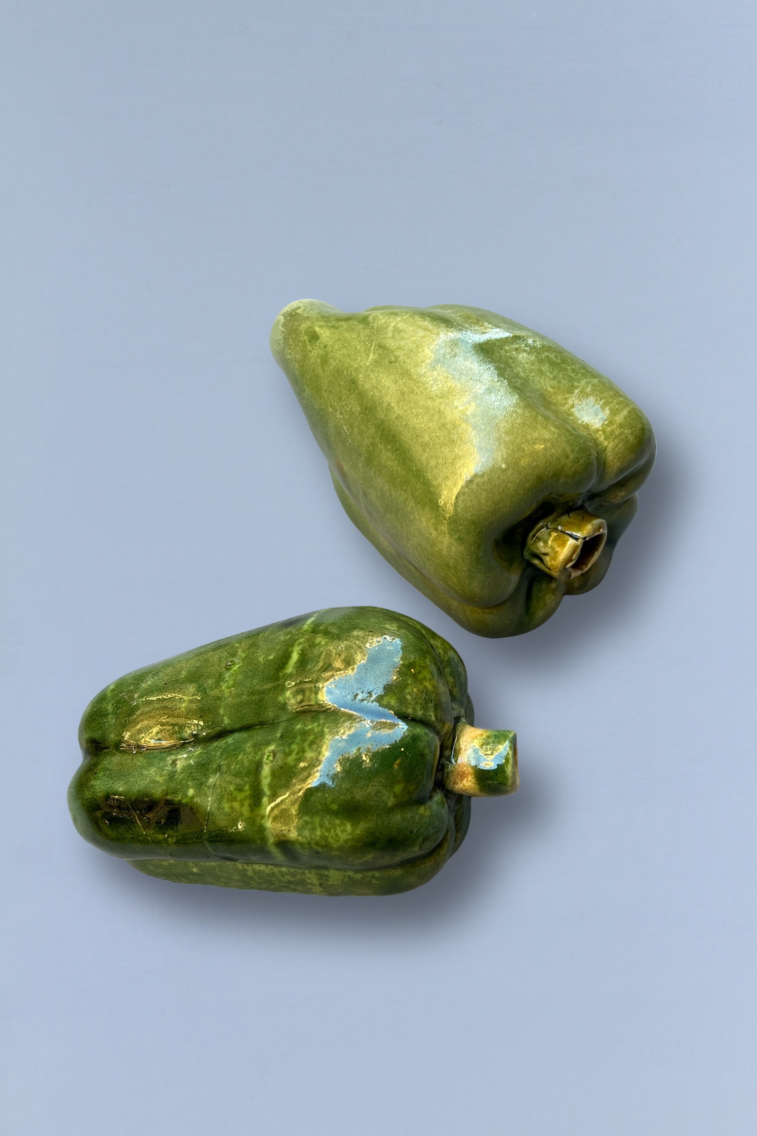 Pimientos de cerámica verde, brillante y artesanal, ideales para decoración de cocina.