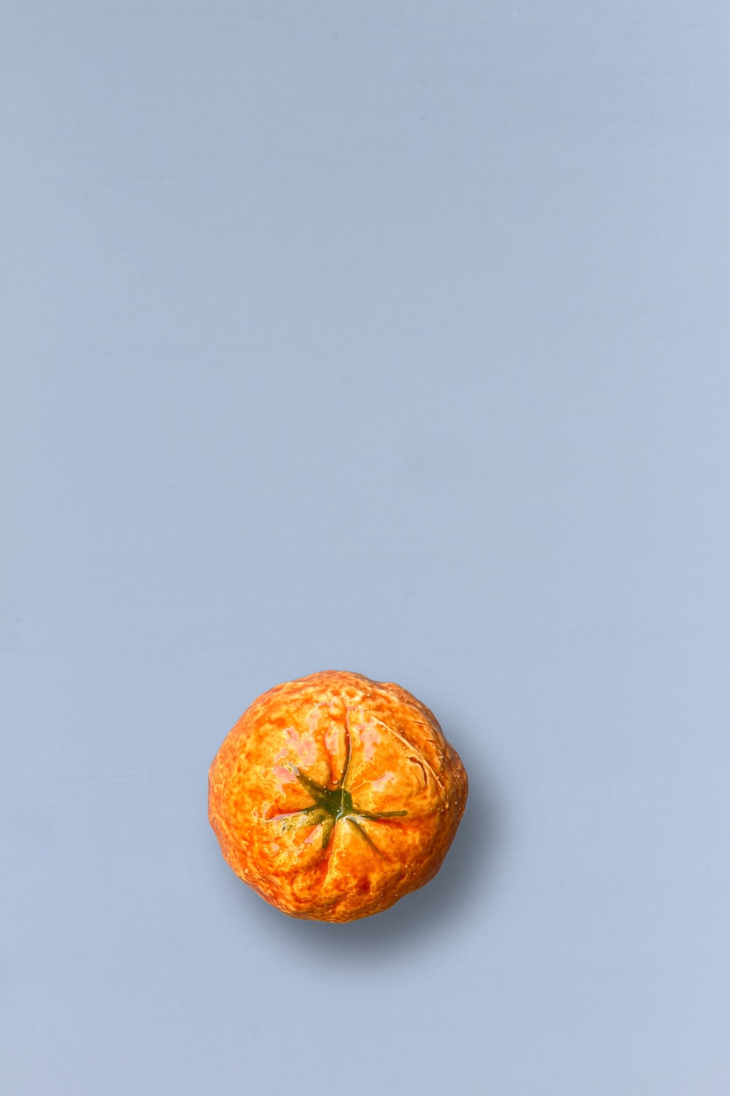 Mandarina naranja sobre fondo gris claro, fresca y jugosa, ideal para snacks saludables o decoración.