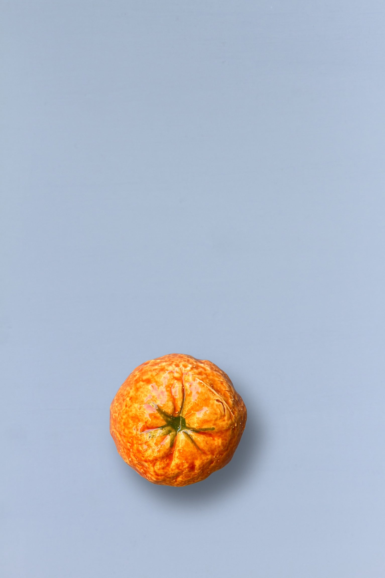 Mandarina naranja sobre fondo gris claro, fresca y jugosa, ideal para snacks saludables o decoración.