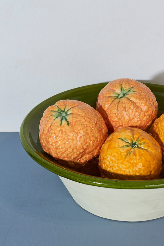 Cuenco de cerámica verde con naranjas decorativas de cerámica texturizada, estilo rústico y vibrantes tonos naranjas.