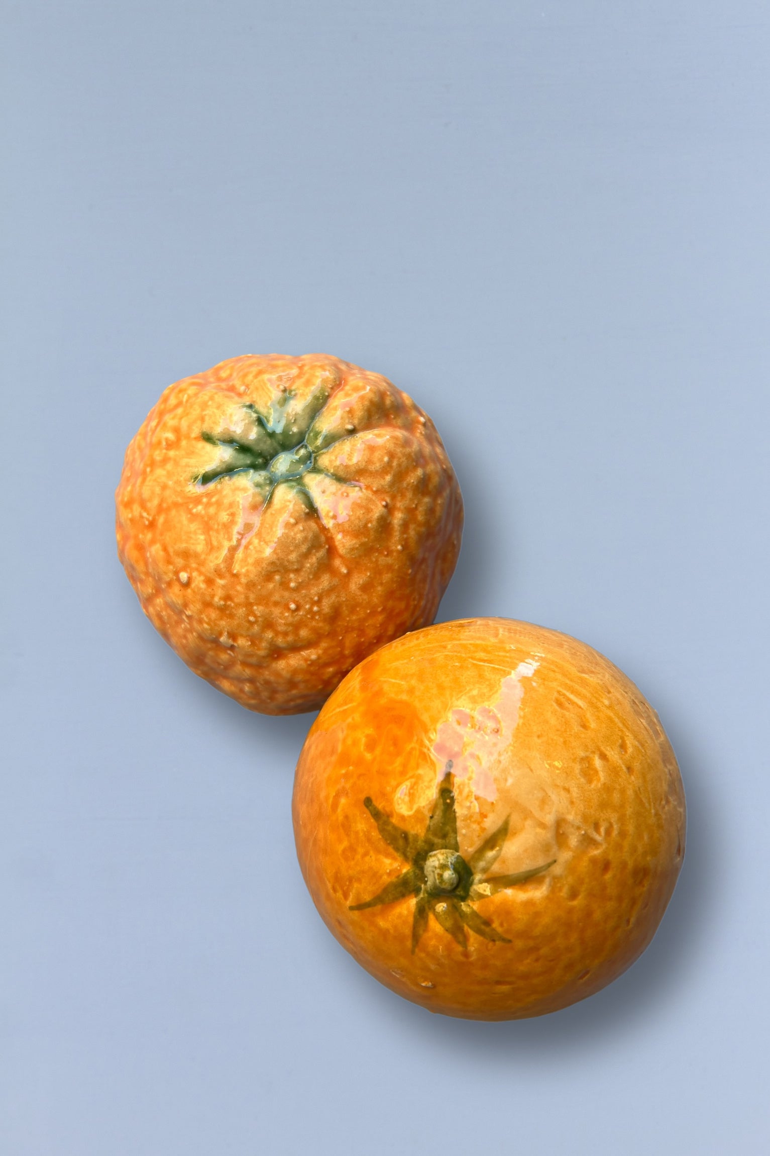 Frutas naranjas de cerámica con acabado brillante y textura realista, perfectas para decoración moderna.