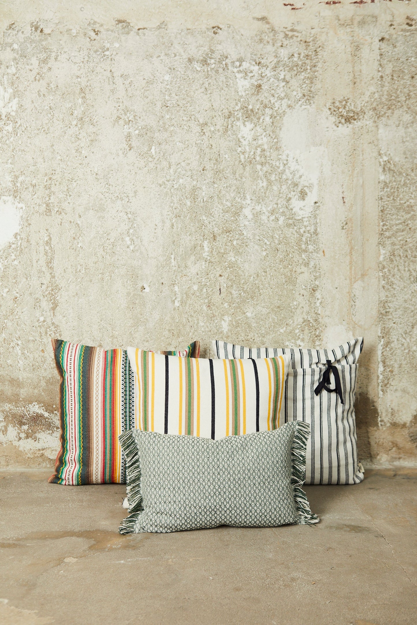 Cojines decorativos de rayas multicolor, algodón y franjas en tonos verde, amarillo y blanco, estilo bohemio.