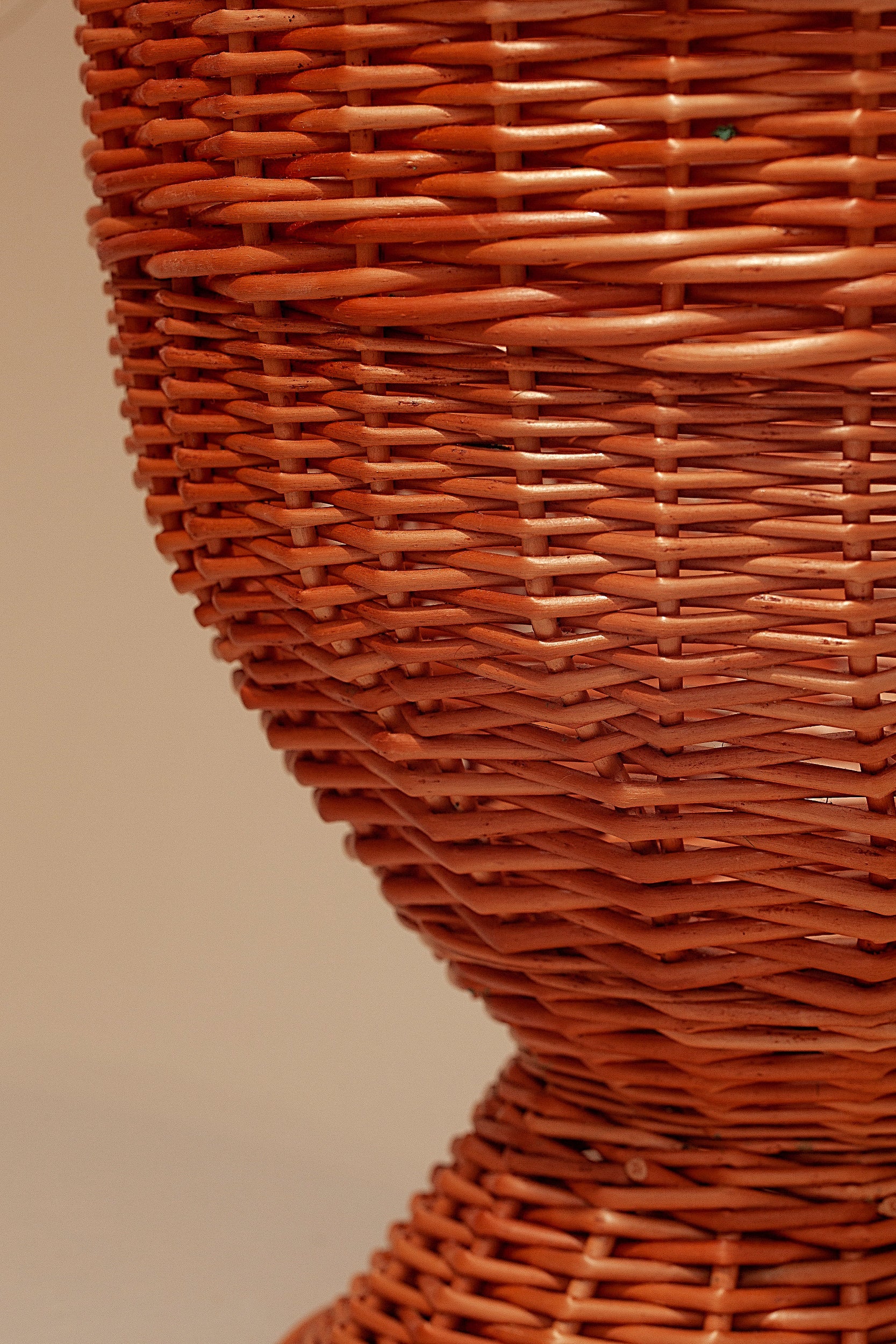 Cesta de mimbre trenzado en color terracota, estilo rústico, ideal para decoración y almacenamiento.