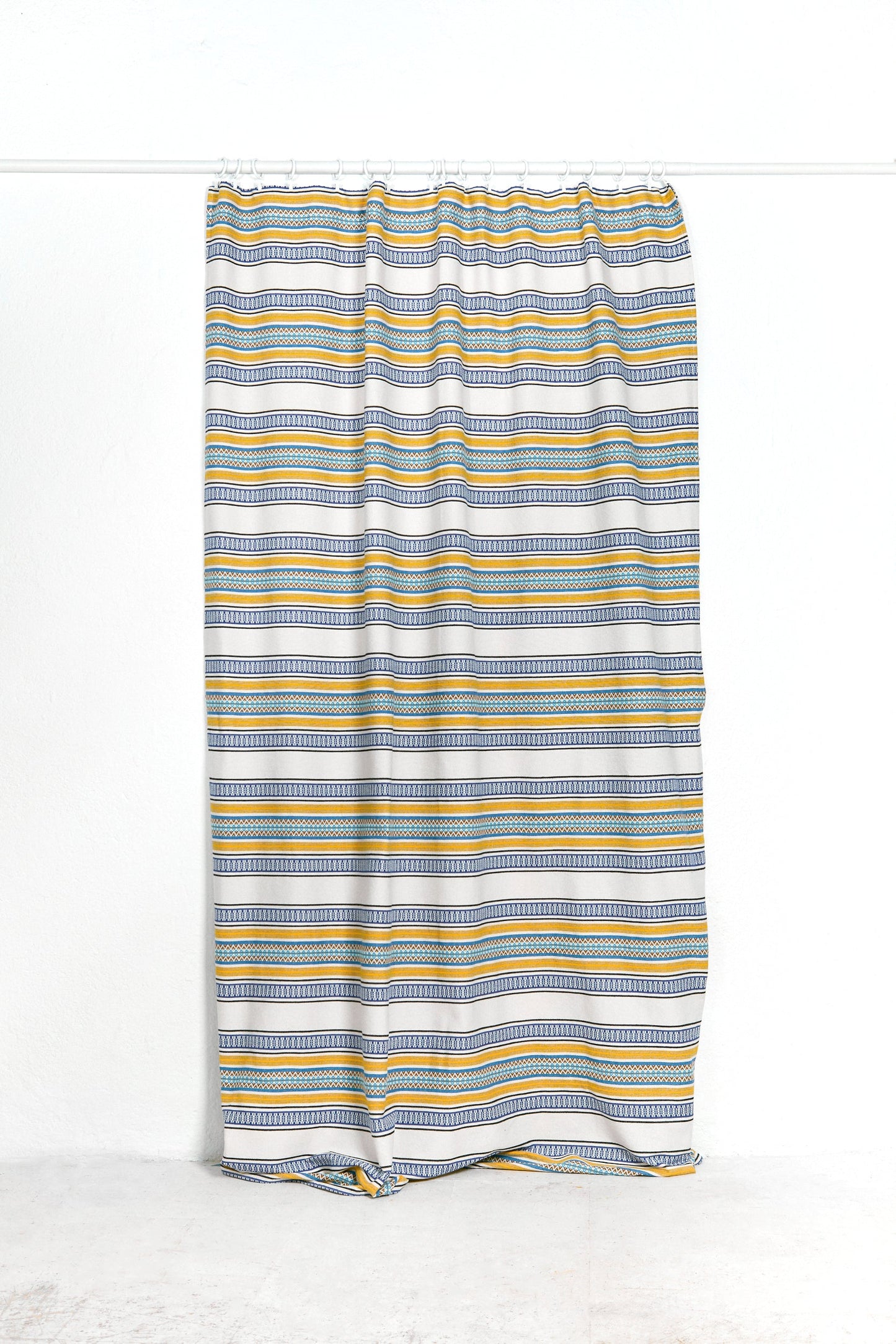 Cortina de tela gris con rayas amarillas y azul, estilo moderno y fresco, ideal para decorar interiores.