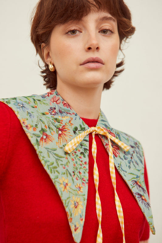 Cuello falso de jacquard celeste con estampado floral multicolor y lazo frontal de cuadros vichy amarillos.