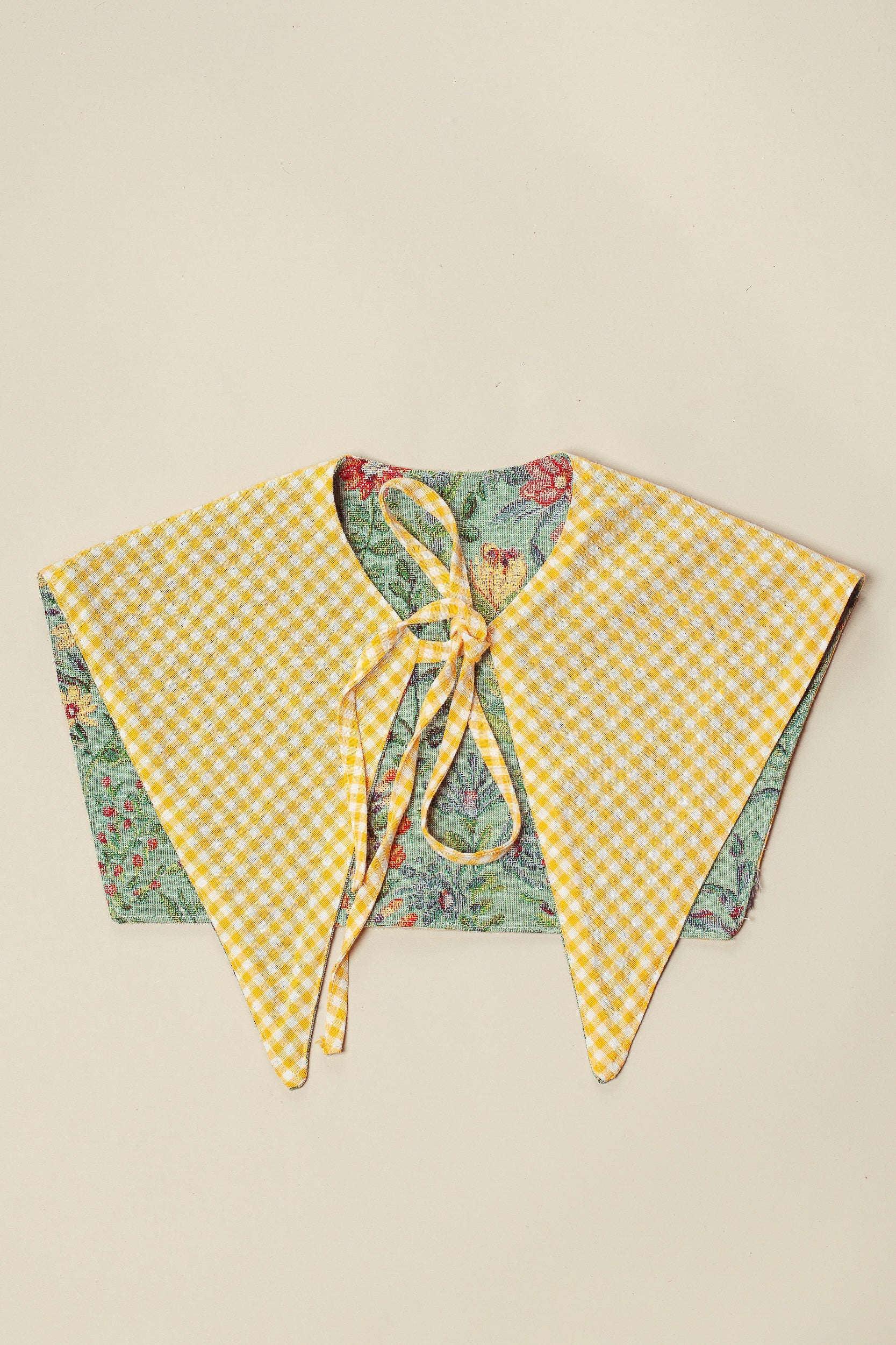 Cuello falso reversible con tejido jacquard de flores celestes y reverso de cuadros vichy amarillos con lazo de amarre.