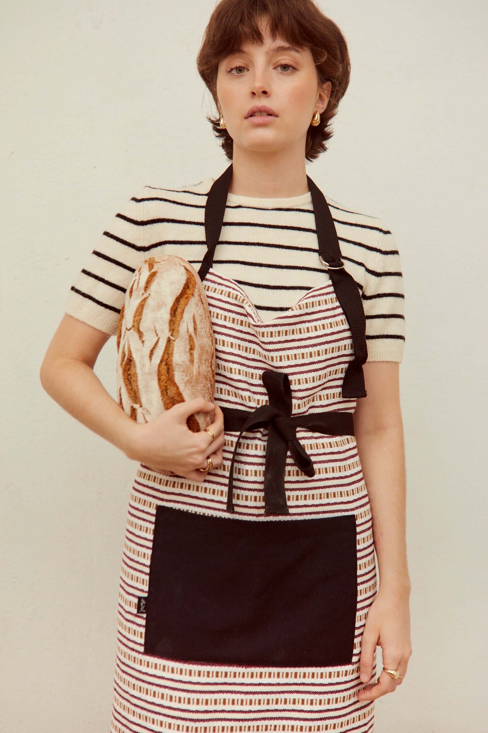 Mujer con delantal tejido cadena granate sosteniendo pan artesanal - delantal cocina 73x85cm hecho España