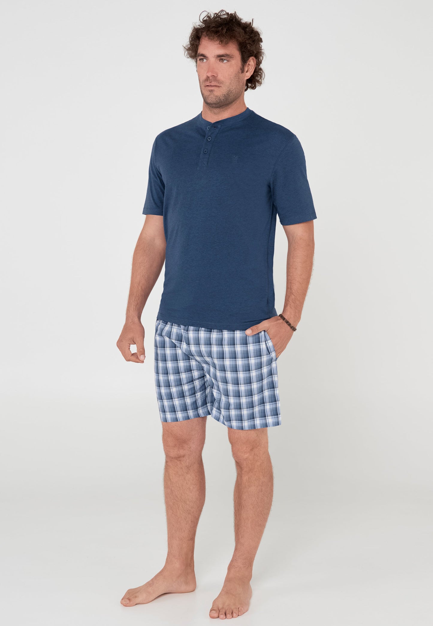 Camisa de hombre azul marino con pantalones cortos de cuadros en azul y blanco, estilo casual y cómodo.