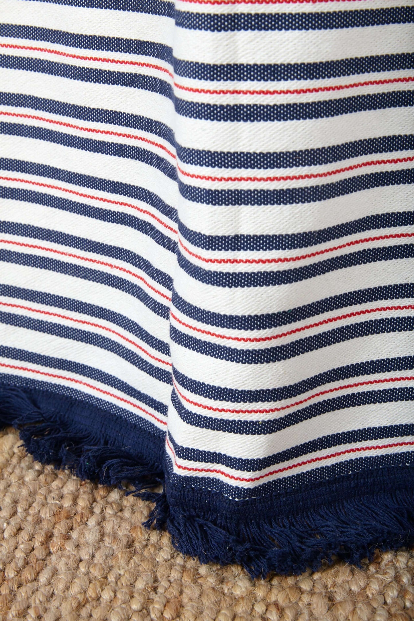  Detalle fleco azul marino cortina loneta rayas blancas rojas sobre alfombra yute - tejido algodón reciclado España
