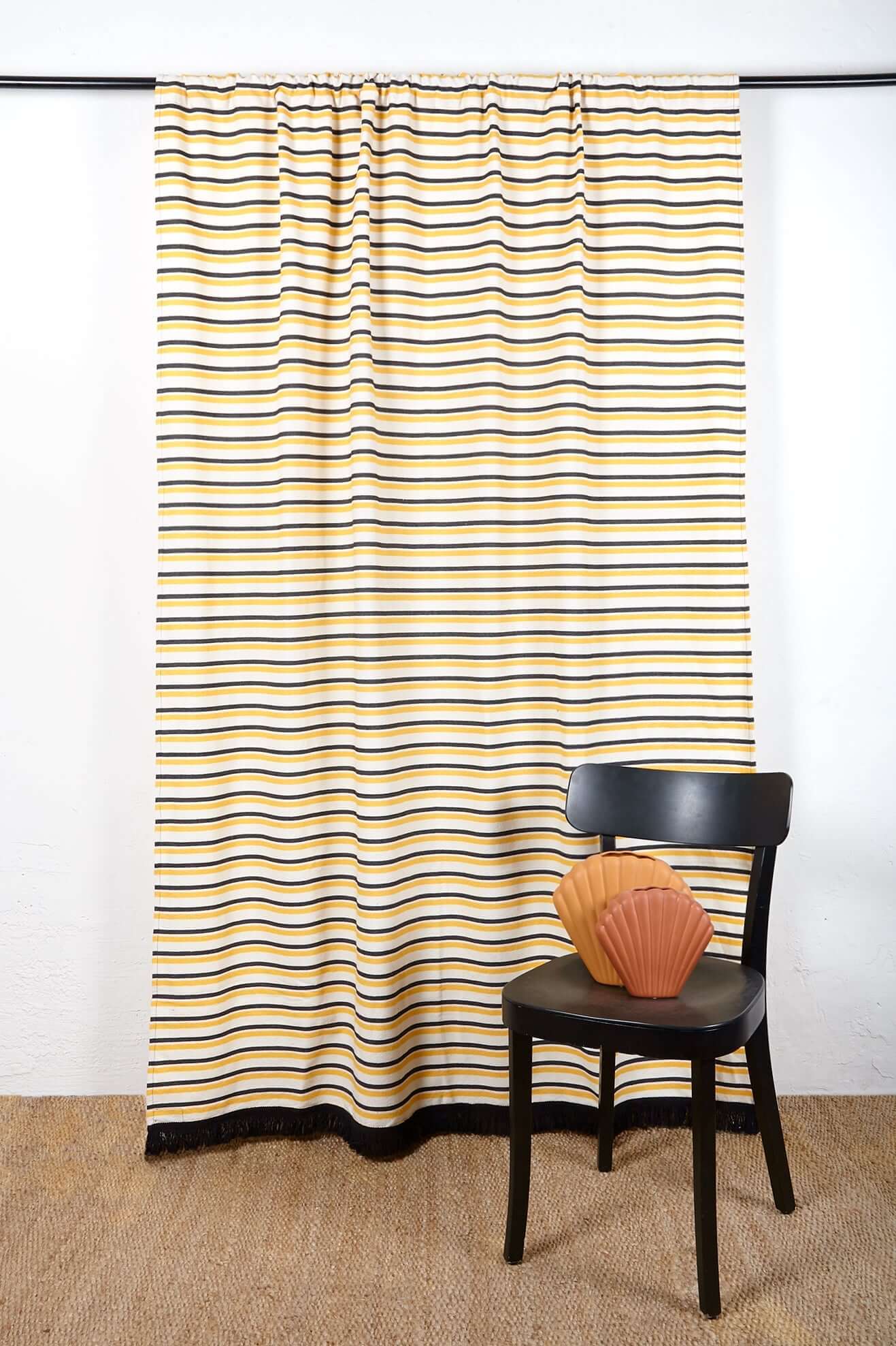 Cortina loneta rayas amarillas negras con silla negra y cojín concha coral - cortina terraza estilo mediterráneo
