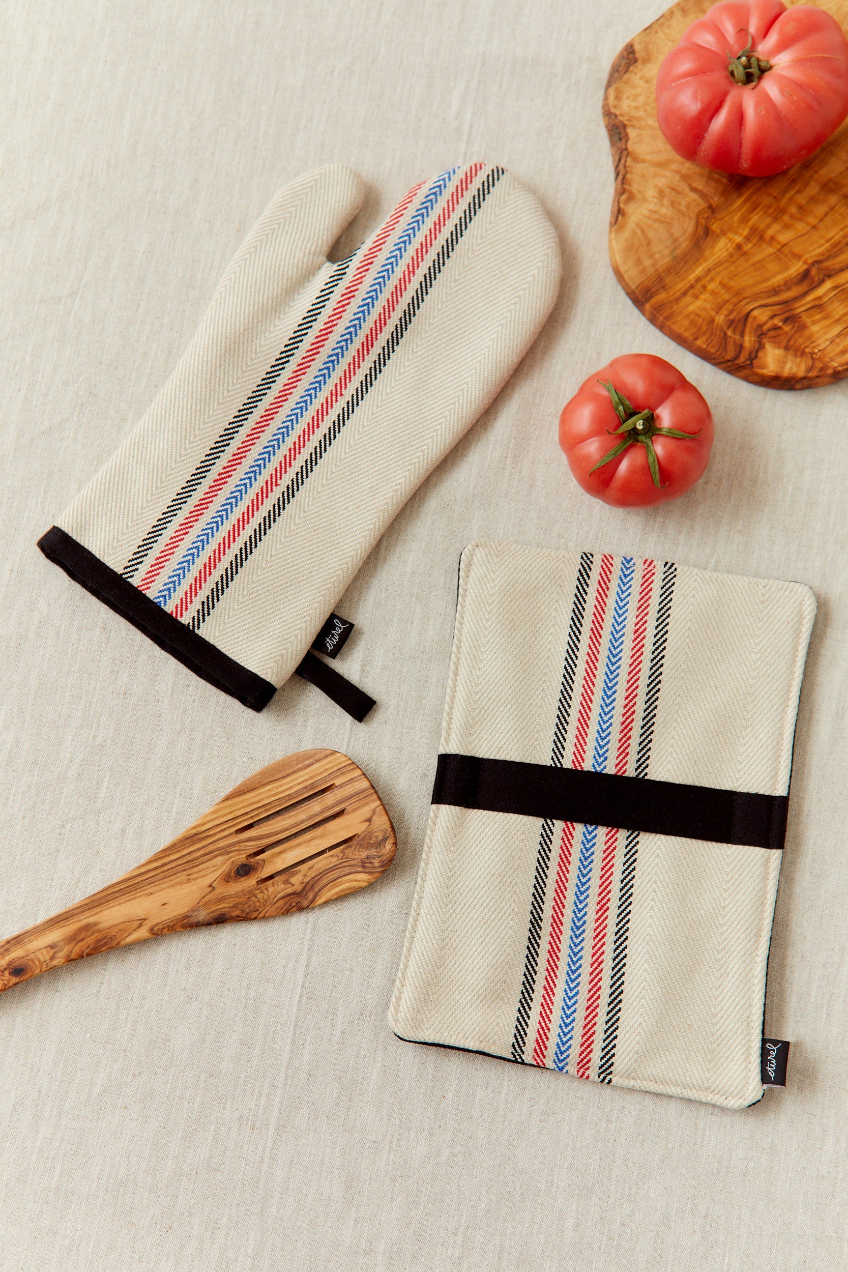 Guantes de cocina beige con rayas azules y rojas, estilo moderno, fabricados en algodón y lino.