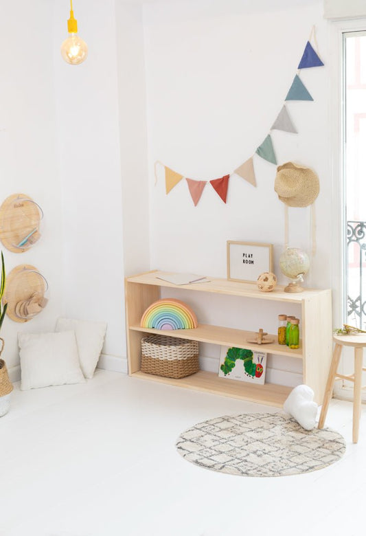 Estante de madera clara con decoración colorida, ideal para habitaciones infantiles y organización de juguetes.