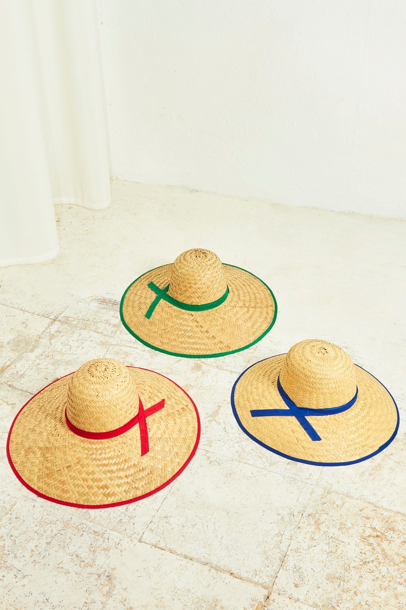 Sombreros de paja trenzada con cintas roja, verde y azul. Estilo clásico y fresco para el verano.