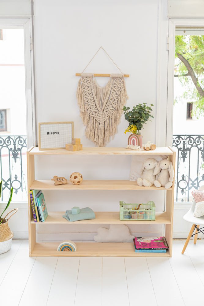 Estantería de madera clara con tres estantes, decorada con adornos bohemios y plantas. Ideal para hogares modernos.