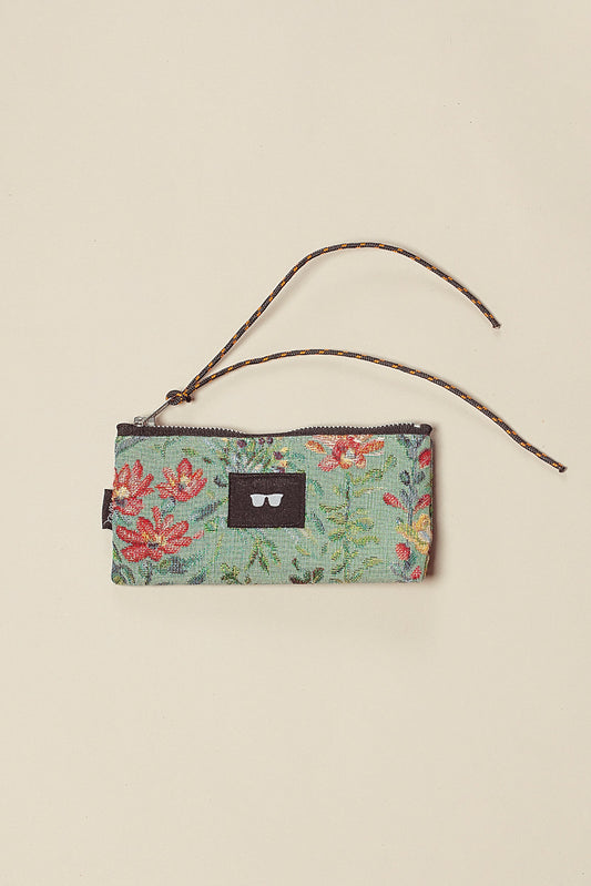 Funda para gafas de tejido jacquard celeste con estampado floral, cierre de cremallera y cordón decorativo.