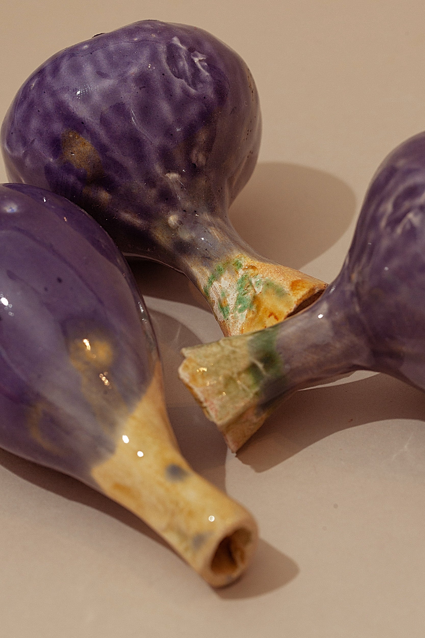 Tres figuritas de cerámica morada con textura, estilo artesanal, perfectas para decoración.