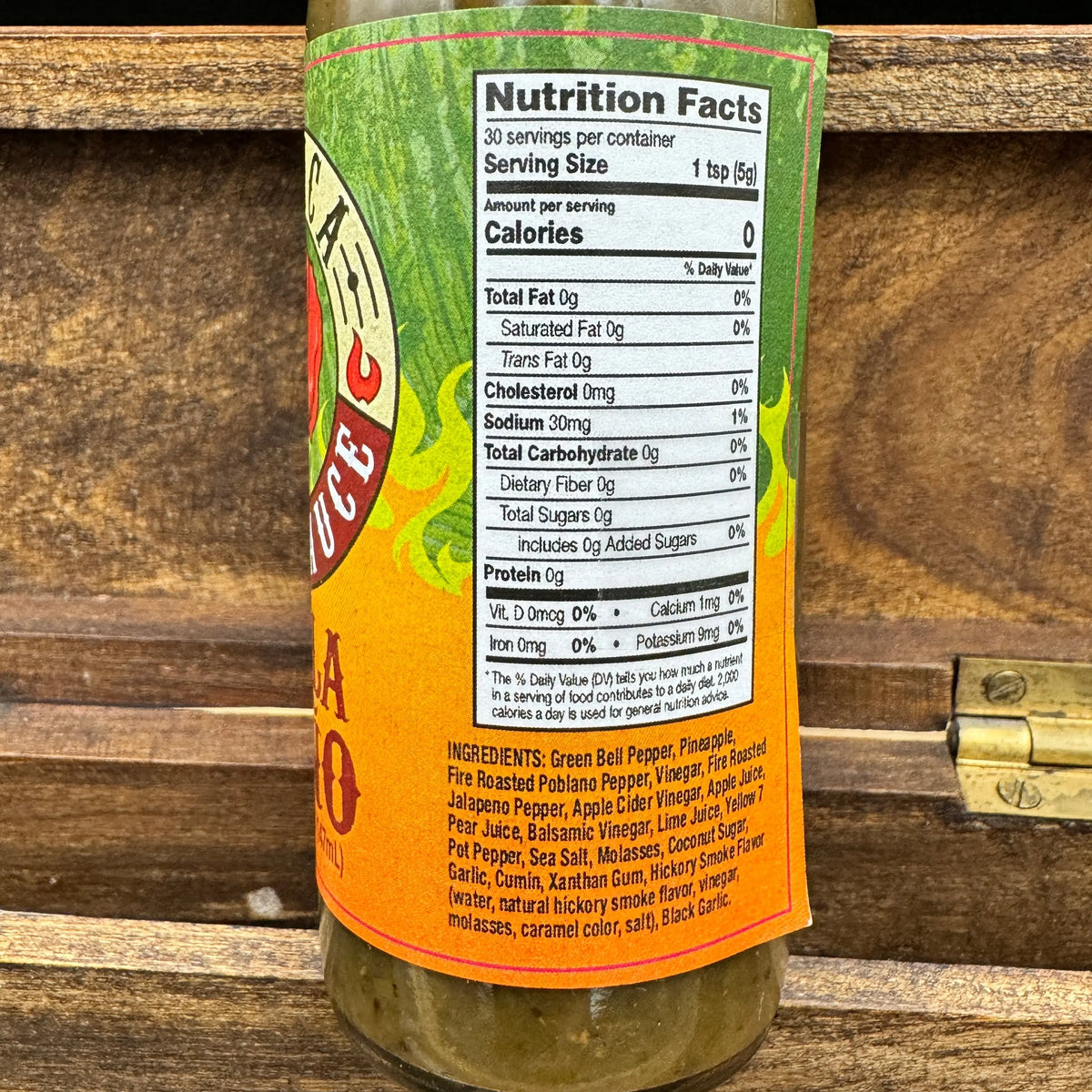 Close-up of a Pobla Peño hot sauce bottle label featuring green and orange accents, nutrition facts, and ingredients.