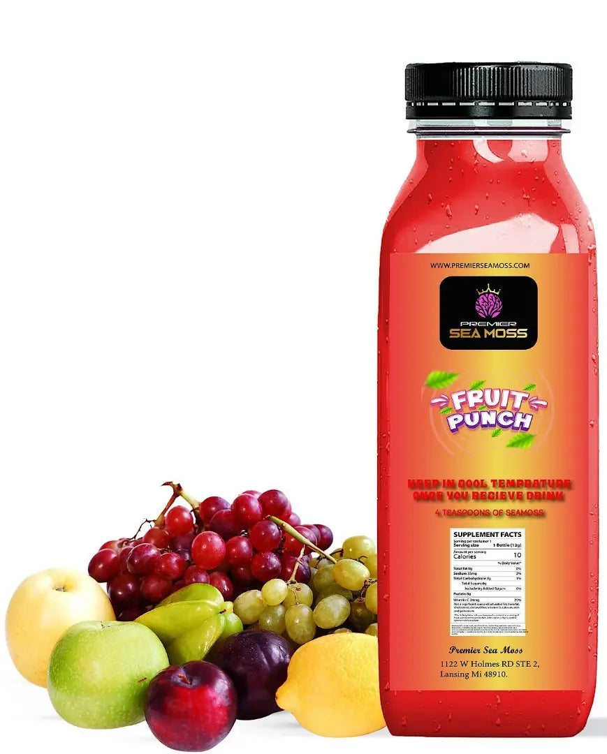 A 12oz bottle of red Premier Sea Moss Fruit Punch next to a cluster of fresh grapes, apples, a lemon, and a plum.