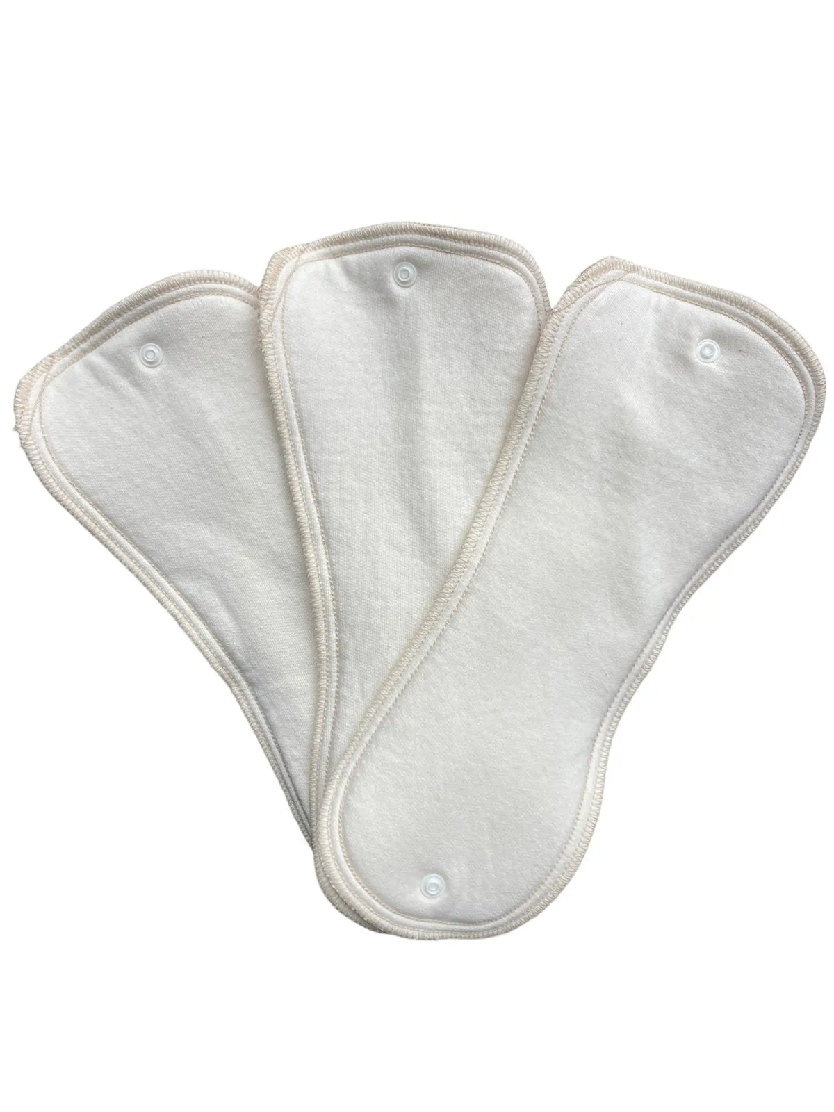 Three cream-colored, hourglass-shaped fabric diaper inserts with snap fasteners, fanned out on a white background.
