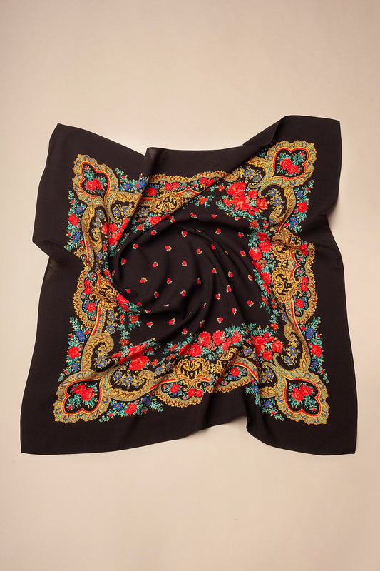 Pañuelo negro con estampado floral, detalles de cadenas doradas y flores rojas en un estilo tradicional portugués.