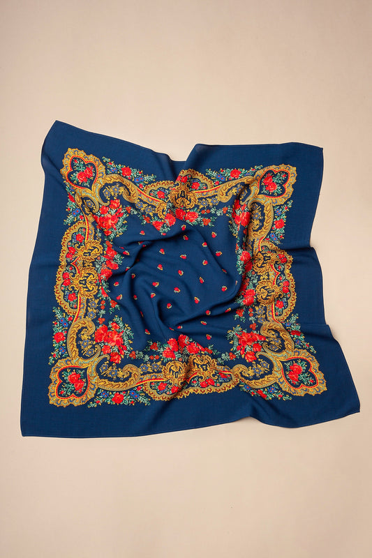 Pañuelo azul marino con estampado de flores rojas y marco de estilo barroco con motivos de cadenas en tonos dorados.
