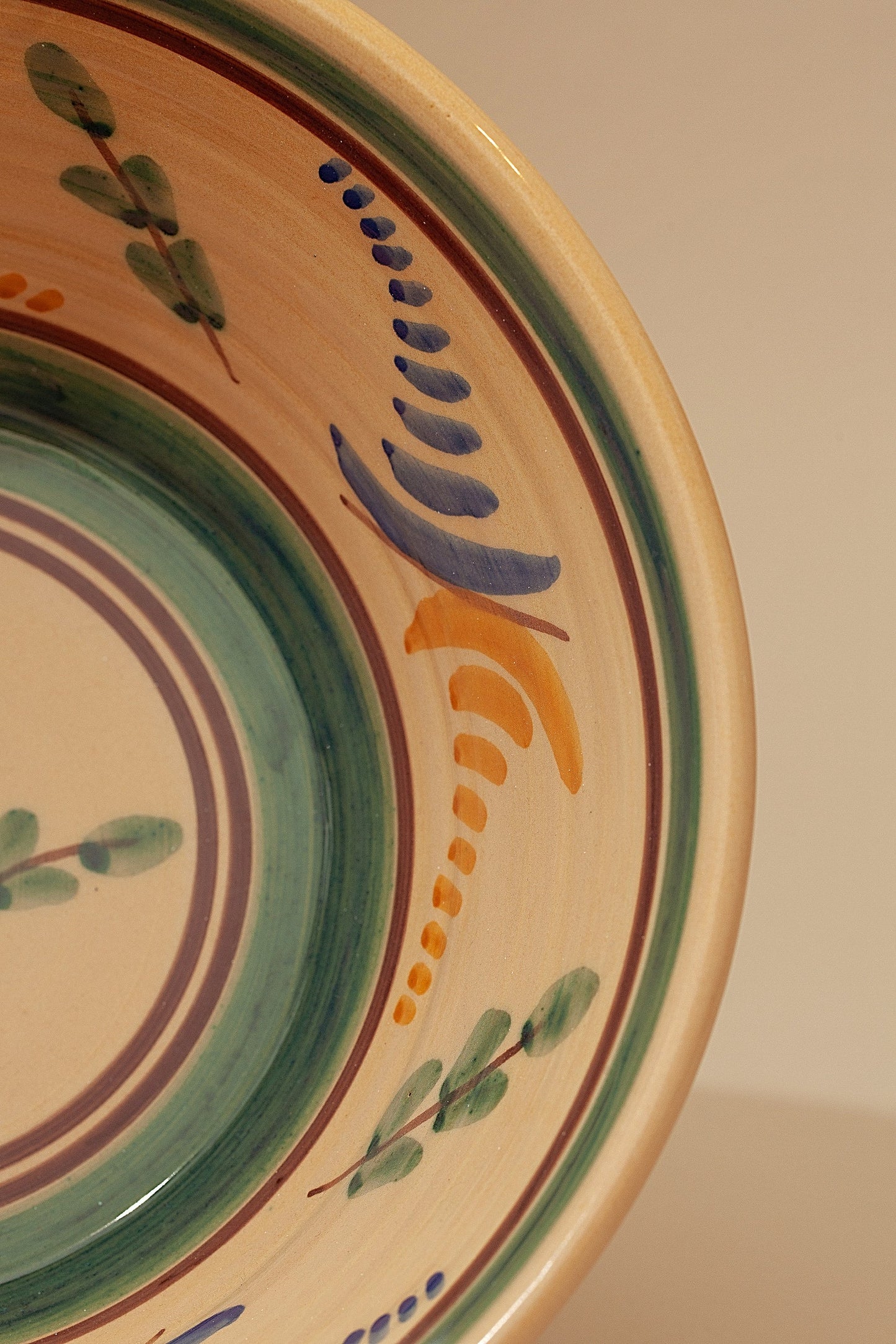 Bol de cerámica decorado en colores azul, naranja y verde, con un diseño floral artesanal.