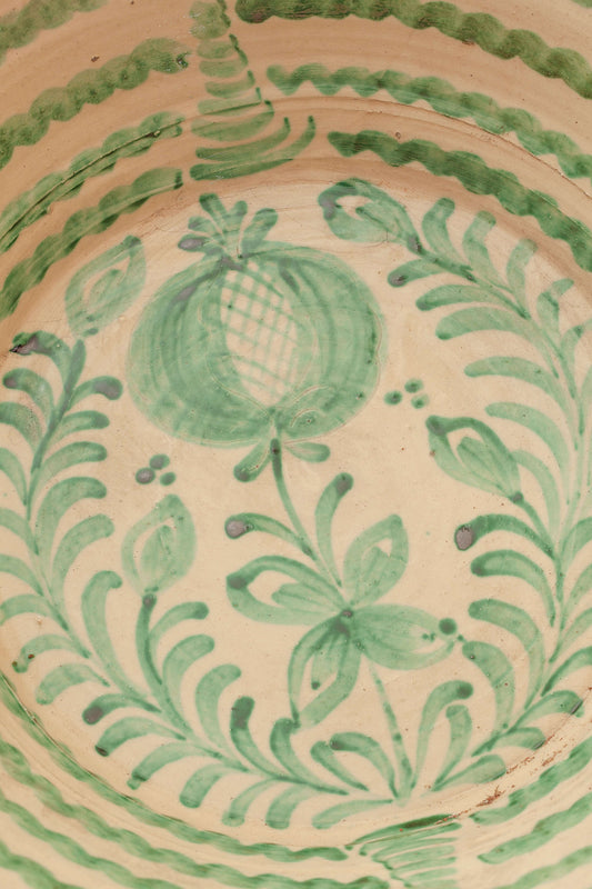 Lebrillo de cerámica tradicional con diseño artesanal de granada y motivos vegetales pintados en color verde.