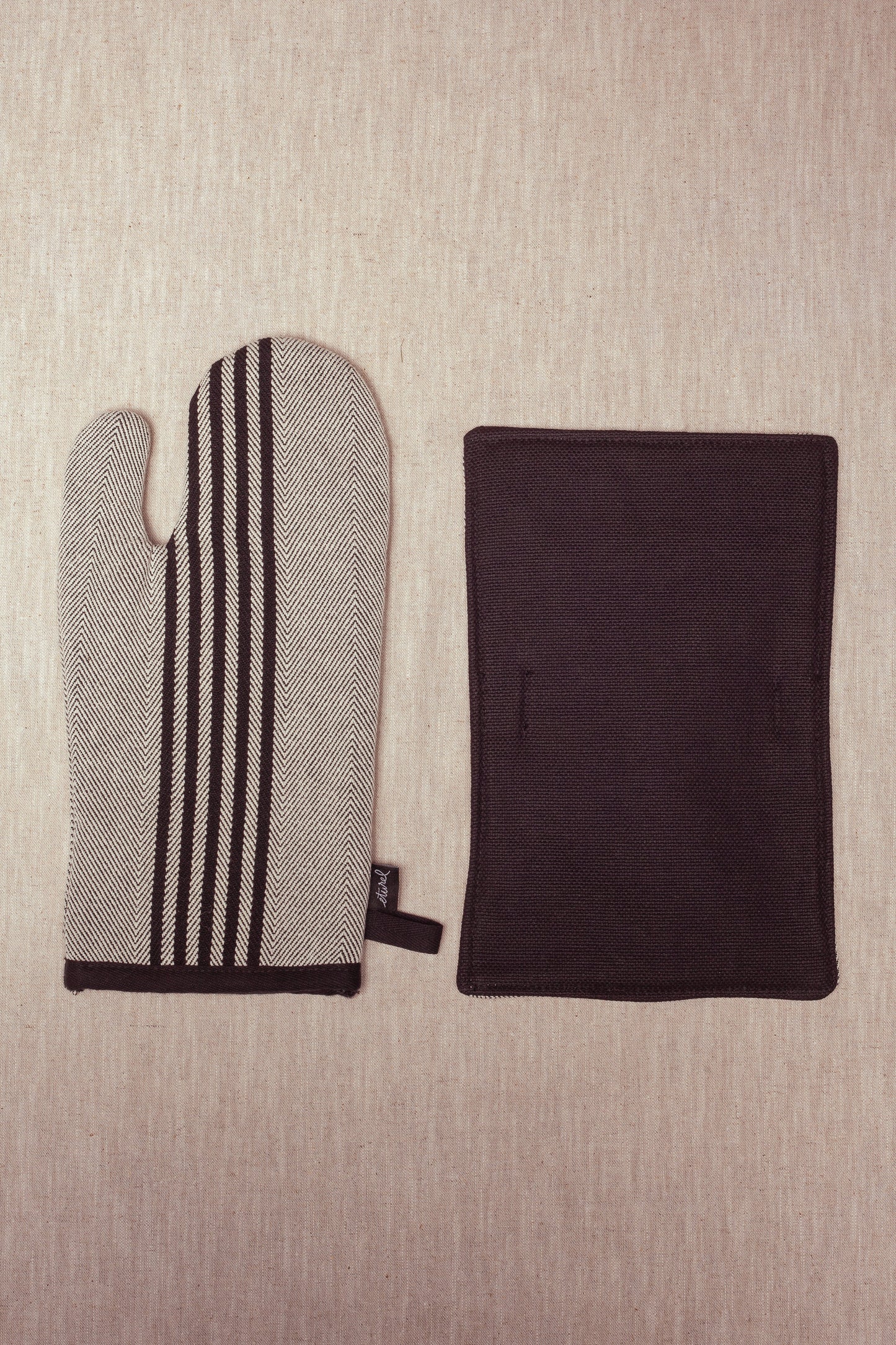 manopla de cocina a rayas en negro y blanco con textil duradero, ideal para proteger las manos del calor.