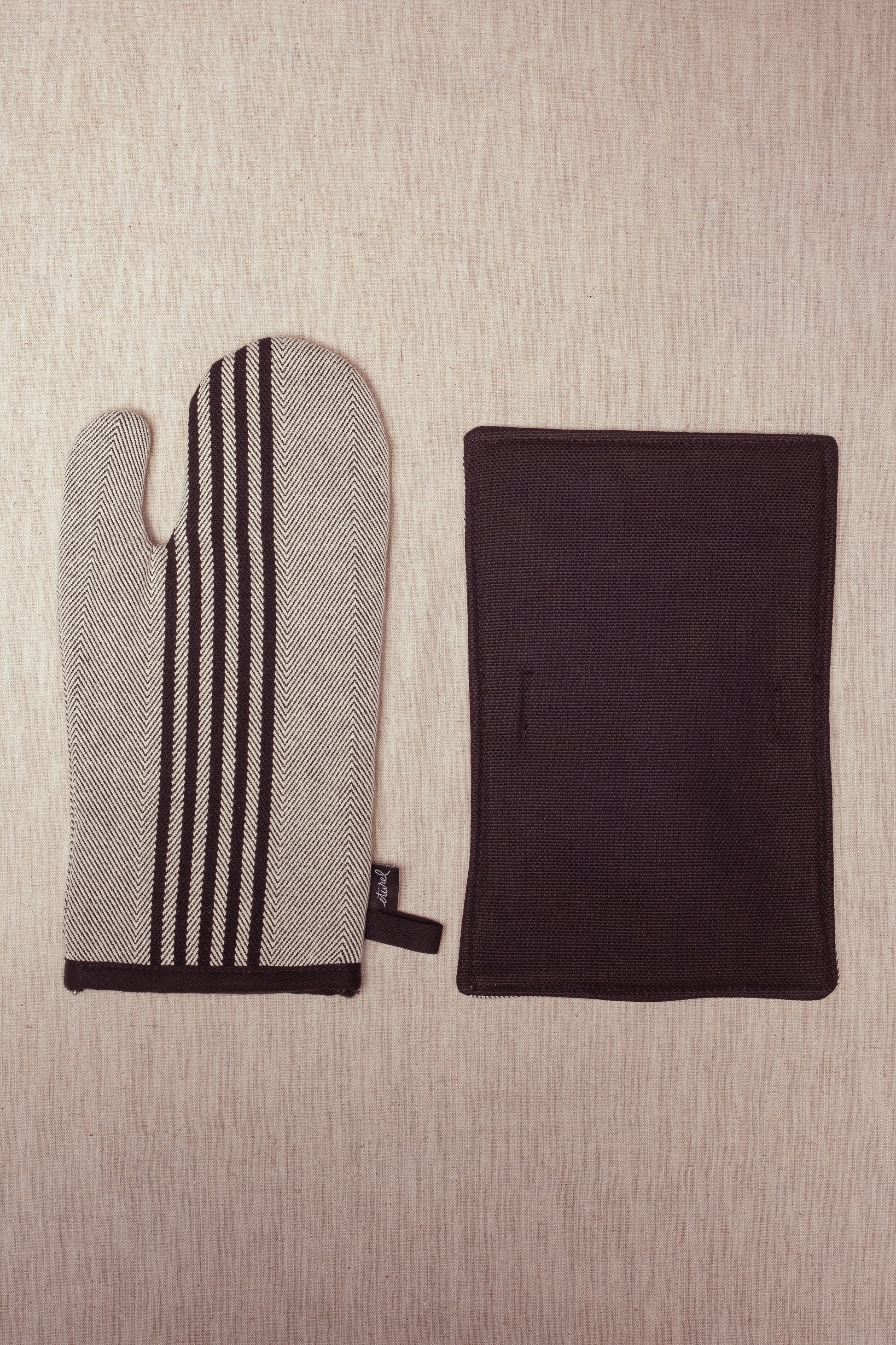 manopla de cocina a rayas en negro y blanco con textil duradero, ideal para proteger las manos del calor.