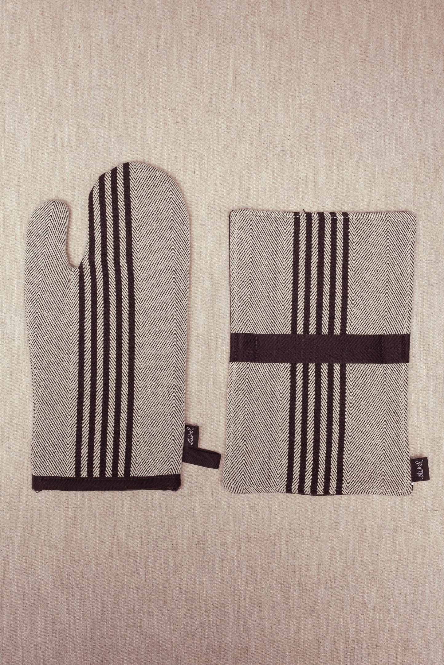 Mitones de cocina de algodón negro y blanco con diseño de espiga, perfectos para un estilo moderno y funcional.