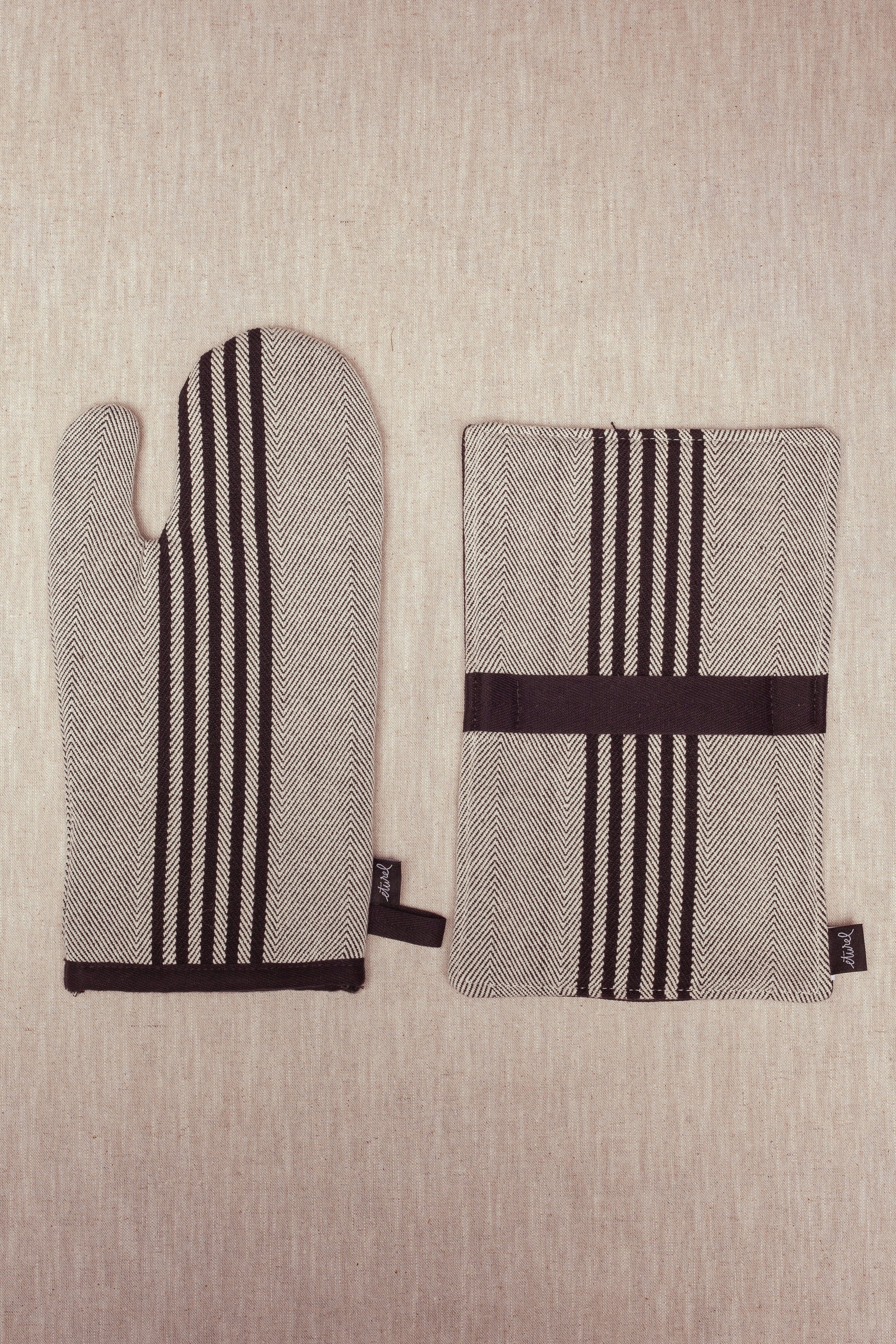 Mitones de cocina de algodón negro y blanco con diseño de espiga, perfectos para un estilo moderno y funcional.