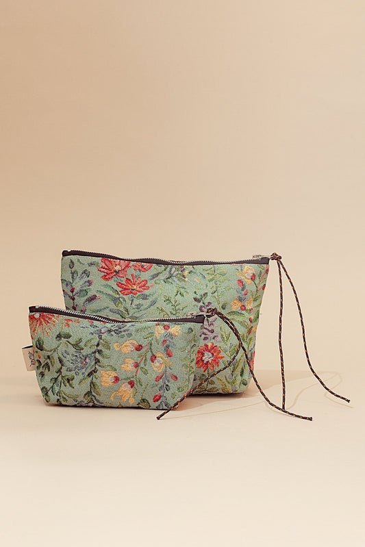 Set de dos neceseres de tela jacquard en tono celeste con estampado floral multicolor y cierre de cremallera con cordón.