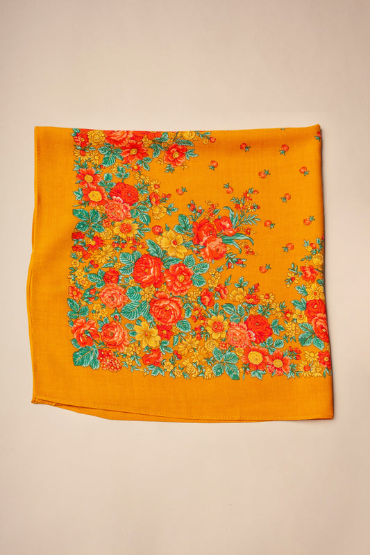 Square ocher scarf featuring a vibrant, traditional floral print with red, orange, and yellow roses and green leaves.
